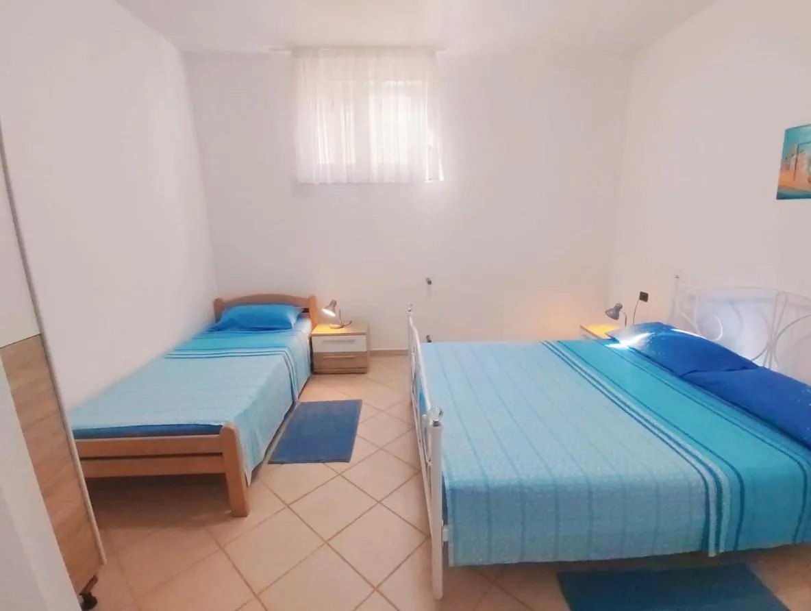 Svijetla spavaća soba s bračnim i jednokrevetom uz prozor